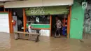 Warga beraktivitas saat banjir merendam Jalan Jatinegara Barat, Jakarta Timur, Selasa (6/2). Deras dan tingginya debit air di Kali Ciliwung membuat Jalan Jatinegara Barat terputus. (Liputan6.com/Arya Manggala)