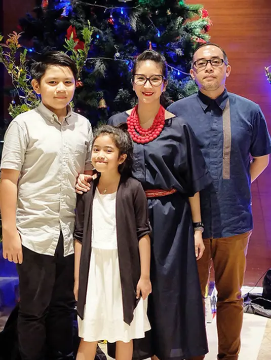 Novita Angie beserta suami dan kedua anaknya pun tak mau kalah. Di momen berharga ini, Angie dan keluarga yang berfoto di depan pohon Natal memancarkan senyuman bahagia. (Instagram/novitaangie)