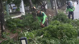Petugas memangkas dahan pohon yang rimbun di sepanjang Jalan Lenteng Agung Raya, Jakarta Selatan, Rabu (2/1). Pemangkasan dilakukan guna mencegah pohon tumbang akibat musim hujan dan angin kencang. (Liputan6.com/Immanuel Antonius)