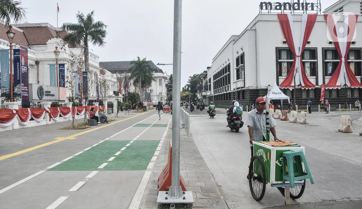 Pedagang makanan keliling saat melintasi jalur pedestrian yang telah rampung dibangun di kawasan wisata Kota Tua, Jakarta Barat, Senin (22/8/2022). Pemprov DKI Jakarta rencananya akan meresmikan jalur pedestrian Kota Tua ini pada akhir Agustus mendatang. (merdeka.com/Iqbal S. Nugroho)