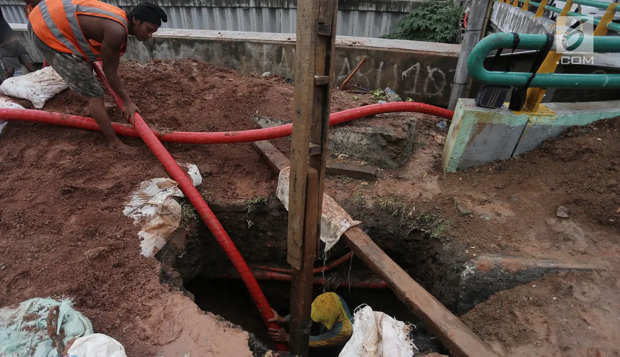 Pekerja memasukkan kabel jaringan utilitas ke dalam tanah di kawasan Kemayoran, Jakarta, Minggu (14/1). PT PLN Disjaya melakukan ini untuk mendukung Pemprov DKI Jakarta mewujudkan smart city. (Liputan6.com/Immanuel Antonius)