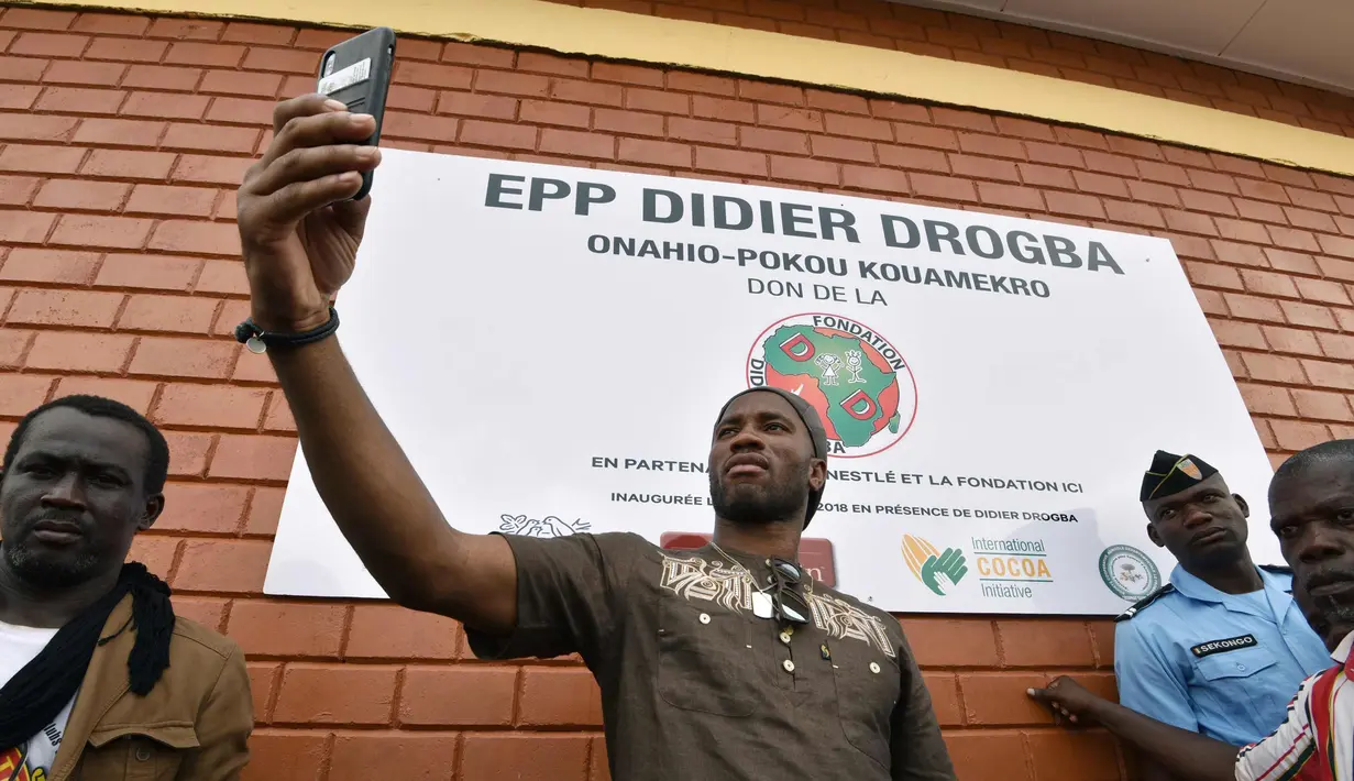 Bintang sepakbola Pantai Gading Didier Drogba berselfie saat peresmian sekolah yang disponsori dirinya di Pokou-Kouamekro, dekat Gagnoa, Pantai Gading tengah barat (17/1). (AFP Photo/Sia Kambou)