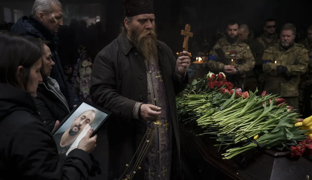 Anggota keluarga dan prajurit Ukraina menghadiri upacara pemakaman marinir Alexandr Khovtun, di Kiev, Ukraina, pada 20 Maret 2022. Khovtun tewas dalam pertempuran di kota Huta-Mezhyhirska, utara Kiev. (AP Photo/Felipe Dana)