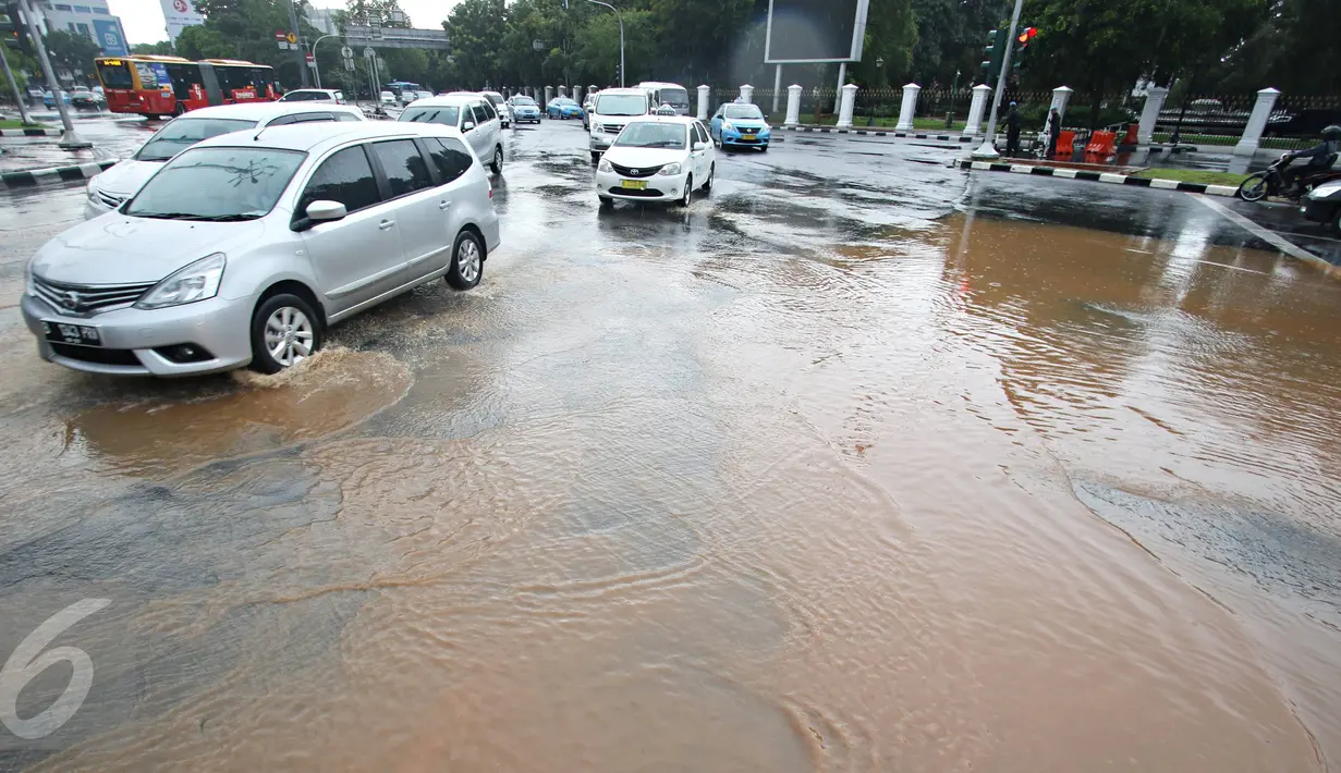 Sejumlah pengendara mobil melaju melewati genangan air hujan yang merendam jalan di depan Istana Merdeka, Jakarta, Selasa (9/2). Hujan deras yang mengguyur kota Jakarta membuat sejumlah jalan protokol tergenang air. (Liputan6.com/Immanuel Antonius)