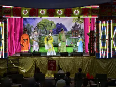 Orang-orang menonton saat rombongan Opera tradisional China, Sai Yong Hong melakukan pertunjukan untuk merayakan Tahun Baru Imlek yang akan datang, di gudang Lhong 1919 di Bangkok (19/1/2022). (AFP/Lillian Suwanrumpha)