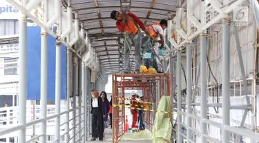 Pekerja mengecat jembatan penyeberangan orang di kawasan Senayan, Jakarta, Jumat (6/7). Pengecatan tersebut merupakan bagian dari proyek revitalisasi JPO guna meningkatnya kenyamanan pejalan kaki. (Liputan6.com/Immanuel Antonius)