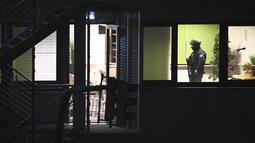Petugas polisi dengan peralatan khusus berjalan melalui gedung yang digunakan gereja Saksi-Saksi Yehuwa di Hamburg, Jerman, Kamis (9/3/2023). Sejumlah orang pun dilaporkan tewas dalam penembakan membabi buta tersebut. (Jonas Walzberg/dpa via AP)