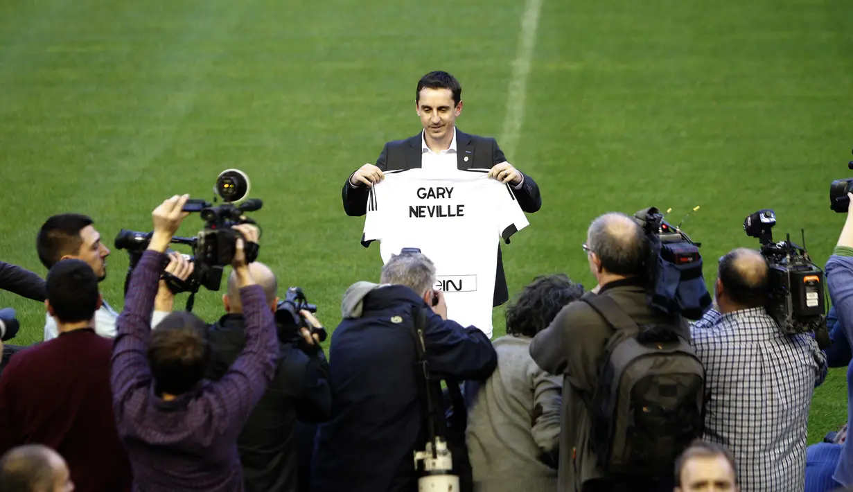 Mantan Pemain Manchester United, Gary Neville berfoto dengan Jersey Valencia bertuliskan namanya di Stadion Mestalla, Kamis (3/12/2015). Gary didaulat sebagai pelatih baru Valencia. (AFP Photo/Jose Jordan)