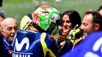 Pembalap Movistar Yamaha, Valentino Rossi menghampiri kekasihnya, Francesca Sofia Novello usai merebut pole position kualifikasi MotoGP Italia 2018. (TIZIANA FABI / AFP)