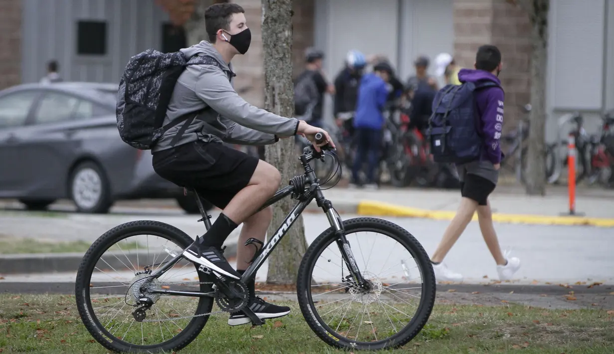 Seorang siswa yang mengenakan masker mengendarai sepeda ke sekolah di Vancouver, British Columbia, Kanada, 21 September 2020. Paparan COVID-19 telah dilaporkan di sedikitnya 20 sekolah di British Columbia sejak para siswa kembali belajar di sekolah dua pekan lalu. (Xinhua/Liang Sen)