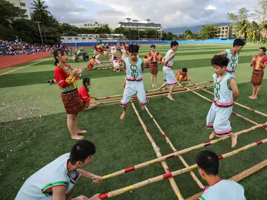 Para pelajar mengikuti kompetisi tari bambu di Sekolah Menengah Baoting yang berada di Wilayah Otonom Etnis Li dan Miao Baoting, Provinsi Hainan, China selatan, pada 18 November 2020. (Xinhua/Zhang Liyun)