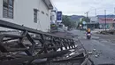 Pengendara motor melewati sebuah gedung yang rusak akibat gempa bumi di Mamuju, Sulawesi Barat, Sabtu (16/1/2021). Jalan dan jembatan yang rusak, pemadaman listrik, dan kurangnya alat berat menghambat evakuasi setelah gempa bermagnitudo 6,2 SR yang melanda Majene- Mamuju. (AP Photo/Azhari Surahman)