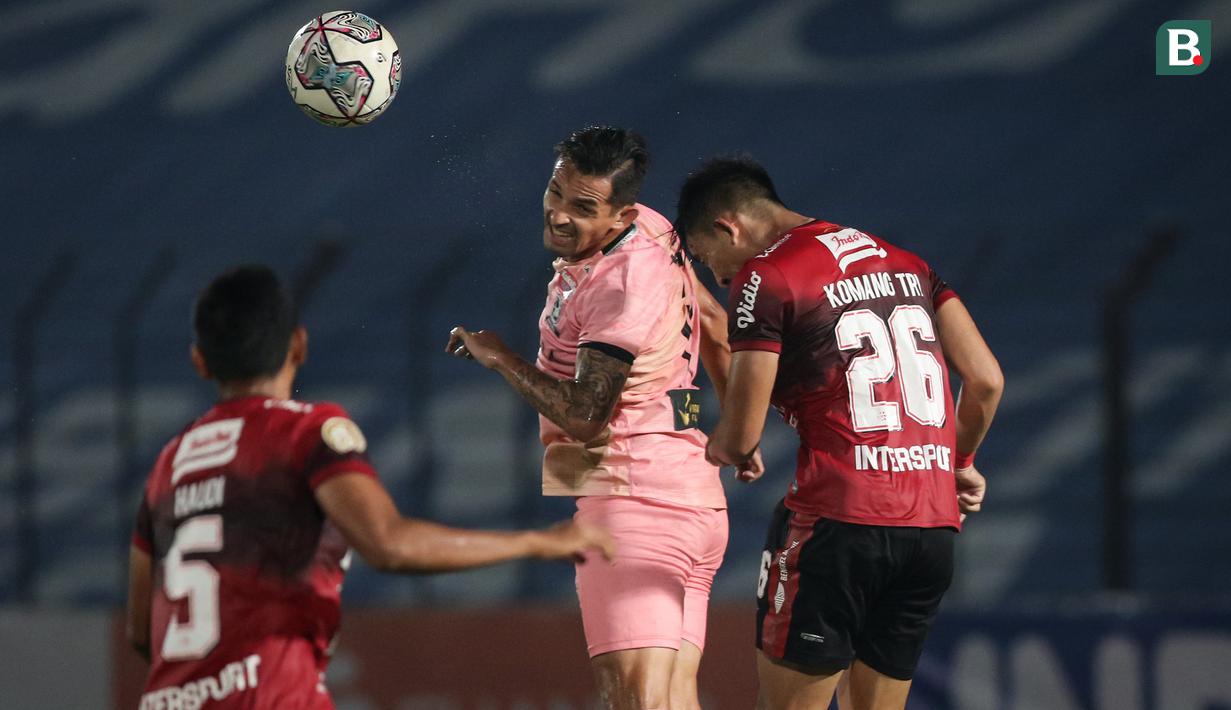 Pemain Madura United, Silvio Escobar Benitez (tengah) berduel udara dengan pemain Bali United, Komang Tri Arta dalam laga pekan ke-16 BRI Liga 1 2021/2022 di Stadion Sultan Agung, Bantul, Kamis (09/12/2021). (Bola.com/Bagaskara Lazuardi)