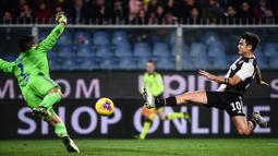 Striker Juventus, Paulo Dybala, berebut bola dengan dengan kiper Sampdoria, Emil Audero, pada laga Serie A 2019 di Stadion Luigi Ferraris, Rabu (18/12). Juventus menang 2-1 atas Sampdoria. (AFP/Marco Bertorello)