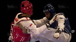 Atlet taekwondo Indonesia, Dinggo Ardian (merah), saat melawan Morrison Samuel, pada final kelas kyorugi -74 kg SEA Games di KLCC, Kuala Lumpur, Minggu (27/8/2017). Kalah di final, Dinggo harus puas meraih perak. (Bola.com/Vitalis Yogi Trisna)