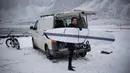 Seorang surfer membawa papannya bersiap berselancar di Unstad, Norwegia Utara (10/3). Surfer ini berselancar di wiliyah Lingkaran Arktik dengan suhu minus 13 derajat Celsius. (AFP Photo/Olivier Morin)