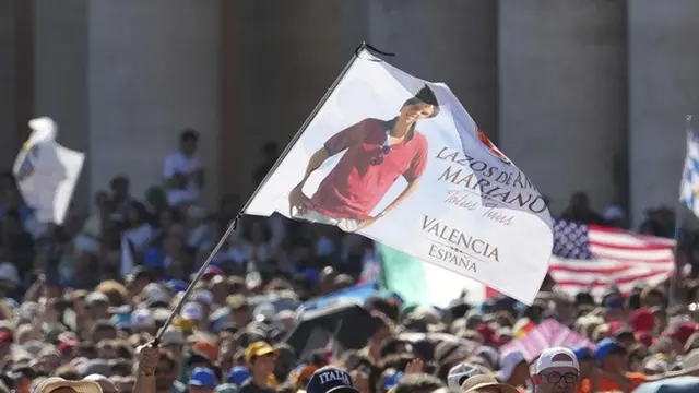 Sebuah bendera bergambar Carlo Acutis dikibarkan dalam Misa kanonisasi Carlo Acutis dan Pier Giorgio Frassati di Lapangan Santo Petrus, Vatikan, Minggu (7/9/2025).