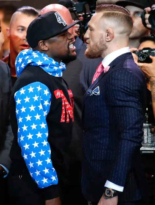 Petinju Floyd Mayweather Jr menatap Juara mixed martial arts Conor McGregor saat jumpa pers di Staples Center Los Angeles, AS (12/7). Mayweather dan McGregor akan bertanding pada 26 Agustus 2017. (AP Photo/Jae C. Hong)