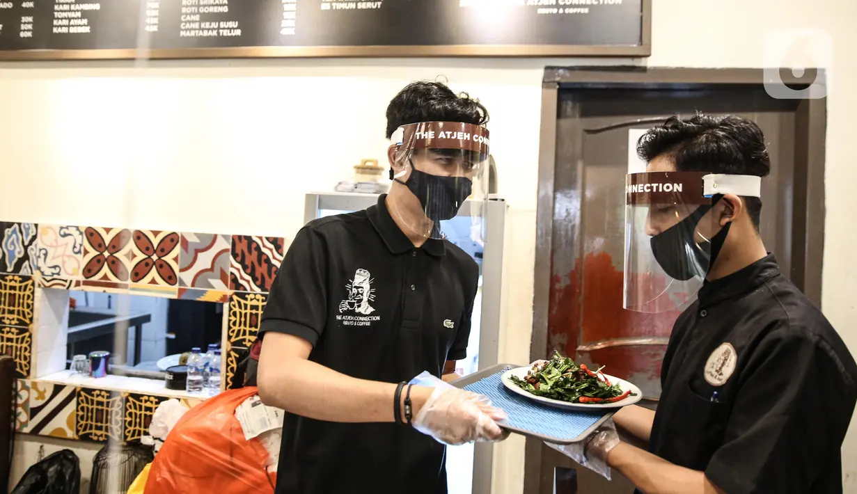 Pramusaji menggunakan pelindung wajah, masker dan sarung tangan saat melayani pelanggan di The Atjeh Connection Coffee and Resto, Jakarta, Senin (8/6/2020). Tempat ini siap menerapkan protokol kesehatan dalam menerapkan tatanan kehidupan baru atau ‘new normal’. (Liputan6.com/Faizal Fanani)