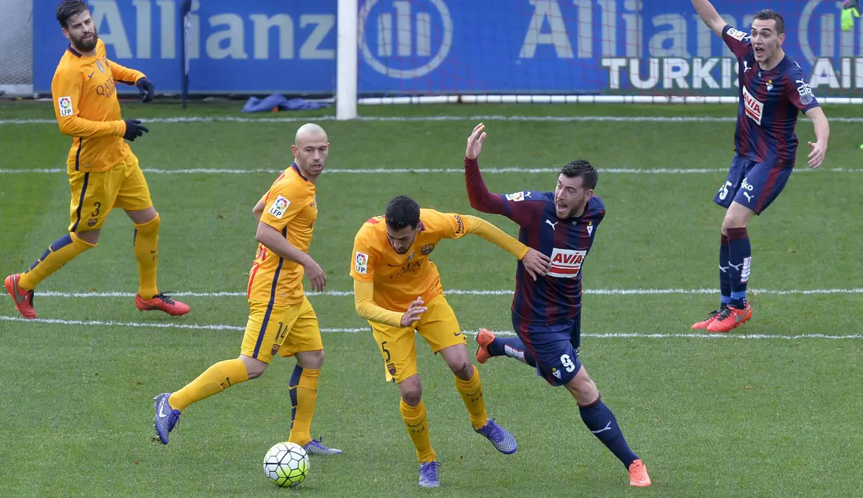 Pemain Eibar,  Sergi Enrich (2kanan) berebut bola dengan pemain Barcelona,  Sergio Busquets pada laga pekan ke-28 La Liga Spanyol 2015-2016 di Stadion Municipal de Ipurua, Minggu (6/3/2016) malam WIB. (REUTERS/Vincent West)
