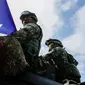 Tentara yang memegang bendera Taiwan terlihat saat latihan peningkatan kesiapsiagaan mensimulasikan pertahanan terhadap gangguan militer China jelang Tahun Baru Imlek di Kota Kaohsiung, Taiwan, 11 Januari 2023. China memperbarui ancamannya untuk menyerang Taiwan dan memperingatkan bahwa negara tersebut telah "bermain api". (AP Photo/Daniel Ceng)