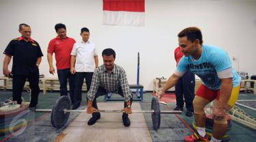 Menpora Imam Nahrawi (keempat kiri) bersiap melakukan angkatan saat meninjau kesiapan akhir atlet angkat besi di PB PABBSI, Jakarta, Selasa (21/6). Tujuh atlet angkat besi akan berlaga di Olimpiade Rio 2016. (Liputan6.com/Helmi Fithriansyah)