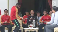 Presiden Joko Widodo (Jokowi) tertawa melihat aksi Marinus Wanewar saat menerima pemain Timnas U-22 Indonesia yang baru saja menjuarai Piala AFF U-22 2019, di beranda belakang Istana Merdeka, Jakarta, Kamis (28/2). (Liputan6.com/Angga Yuniar)