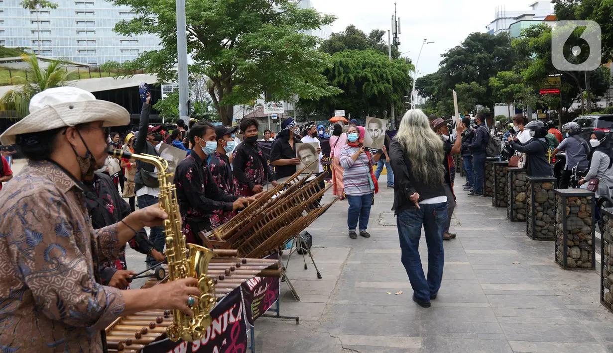 Seniman memainkan alat musik saat mengikuti Karnaval Seni Budaya di Taman Ismail Marzuki, Jakarta, Rabu (10/11/2021). Karnaval tersebut menampilkan pertunjukan seni budaya digelar sebagai rangkaian perayaan HUT ke-53 Taman Ismail Marzuki (TIM). (Liputan6.com/Herman Zakharia)
