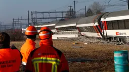 Petugas saat melihat kondisi kereta yang bertabrakan di Zurich, Swiss, (20/2/2015). Kereta bertabrakan di Swiss yang menyebabkan beberapa orang terluka dan rute komuter tergangu. (Reuters/ Arnd Wiegmann)