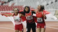 Pelari Indonesia, Putri Aulia, Ni Made Arianti, Endang Sari Sitorus, melakukan selebrasi usai menjuarai lari 100M T13 pada Asian Para Games di SUGBK, Jakarta, Rabu (10/10/2018). Indonesia meraih memborong tiga mendali. (Bola.com/M Iqbal Ichsan)