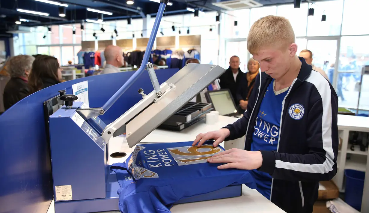 Seorang staf sedang mempersiapkan jersey tim untuk dijual dengan tulisan "Champions". (3/5/2016). (Action Images via Reuters/Matthew Childs)