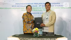 Direktur Utama BPJS Ketenagakerjaan (BPJAMSOSTEK) Anggoro Eko Cahyo (kanan) dan Direktur Utama Bank Aceh Haizir Sulaiman (kiri) menunjukkan naskah Perjanjian Kerja Sama dalam Rangka Pemberian Manfaat Layanan Tambahan (MLT) di Plaza BPJAMSOSTEK Jakarta, Kamis (24/03/2022). (Liputan6.com/Fery Pradolo)