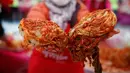 Seorang wanita memperlihatkan Kimchi, hidangan tradisional Korea Selatan, selama Festival Kimchi Seoul di pusat kota Seoul, Jumat (44/11). Kimchi merupakan makanan yang terbuat dari sawi putih atau lobak yang difermentasikan. (REUT (REUTERS / Kim Hong-Ji)