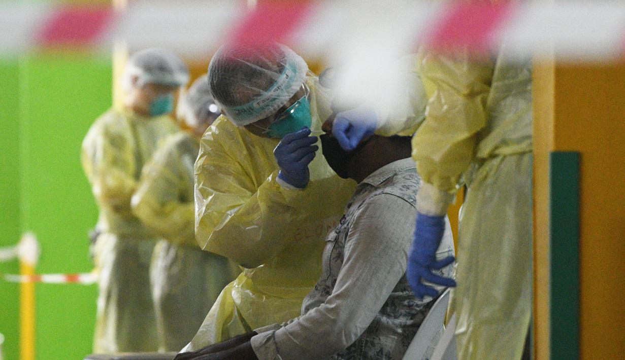 Petugas kesehatan mengumpulkan sampel usap (swab) untuk pengujian COVID-19 dari para pekerja yang siap kembali bekerja di pusat penapisan (screening) regional di Singapura (10/6/2020). (Xinhua/Then Chih Wey)