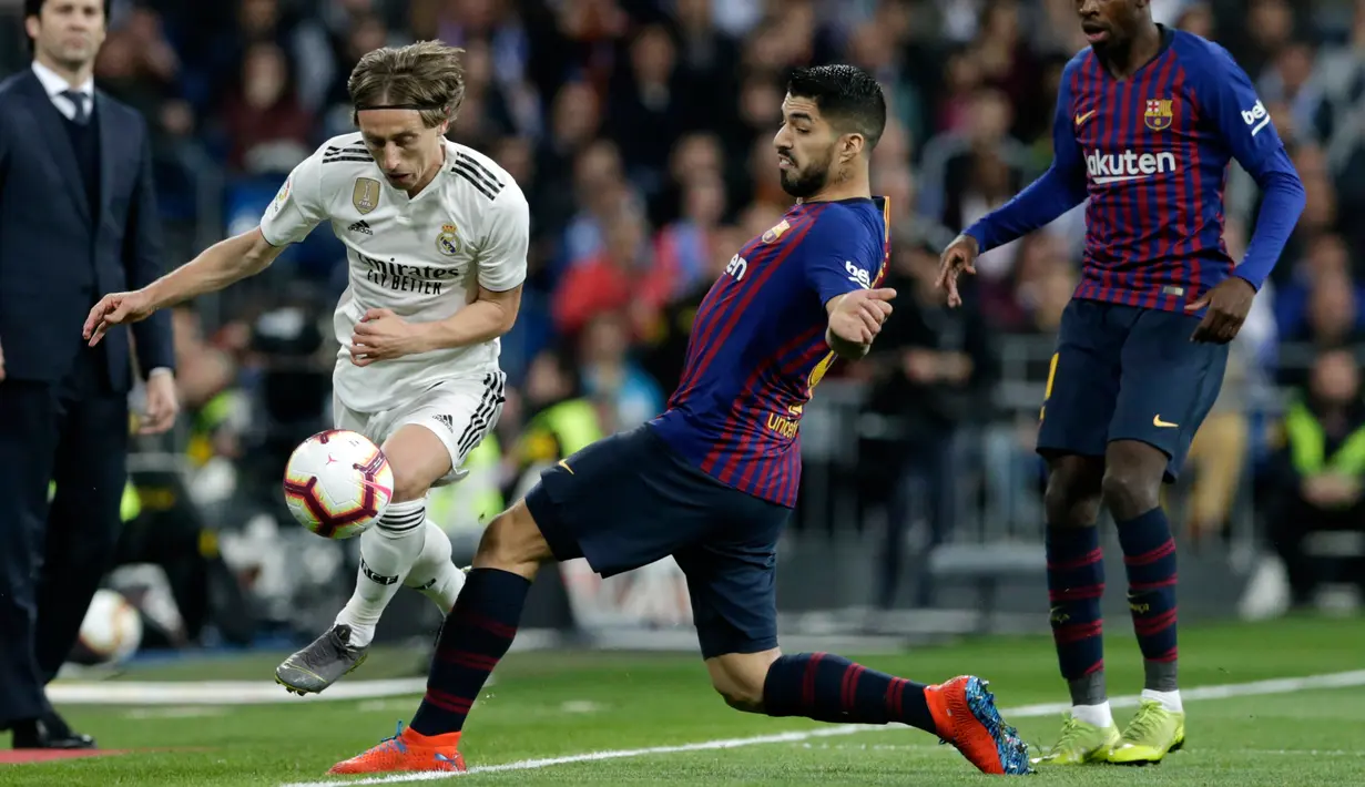 Gelandang Real Madrid, Luka Modric berusaha melewati striker Barcelona, Luis Suarez selama pertandingan lanjutan La Liga Spanyol di Santiago Bernabeu, Madrid (2/3). Barcelona menang tipis atas Real Madrid 1-0. (AP Photo/Andrea Comas)