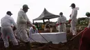 Petugas melakukan pemakaman dengan prosedur Covid-19 di TPU Tegal Alur, Jakarta, Minggu (3/12/2021). DKI Jakarta menjadi provinsi yang paling banyak melaporkan kasus harian tertinggi hingga 1.894 kasus. (Liputan6.com/Angga Yuniar)