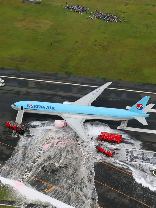 Gambar udara menunjukkan sejumlah penumpang berdiri di dekat pesawat Korean Air Lines setelah asap keluar dari bagian mesin sebelah kiri itu di bandara Haneda di Tokyo, Jepang, (27/5). (Reuters/ Kyodo)