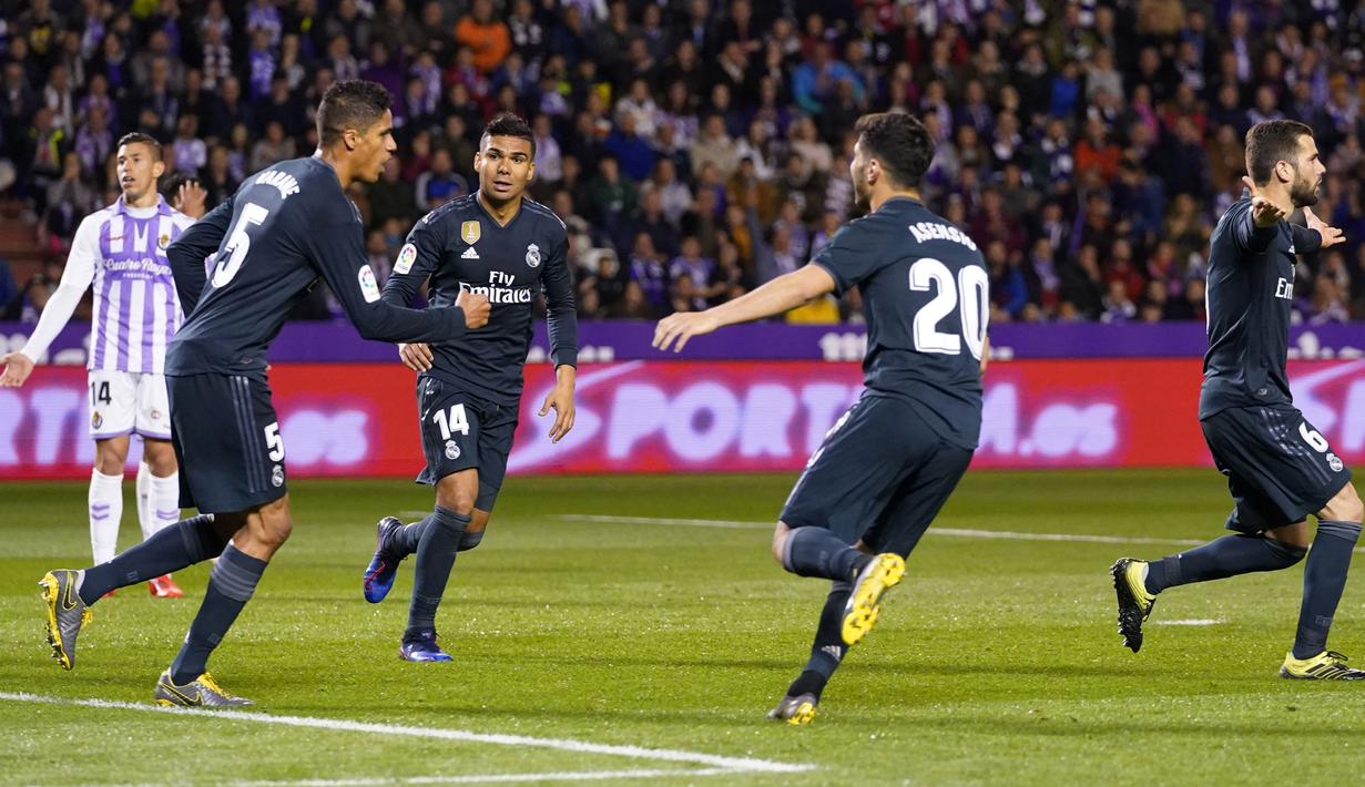 Bek Real Madrid, Raphael Varane (kedua kiri) berselebrasi usai mencetak gol ke gawang Real Valladolid selama pertandingan lanjutan La Liga Spanyol di stadion Jose Zorrilla,Valladolid (10/3). Madrid menang telak 4-1 atas Valladolid. (AFP Photo/Cesar Manso)