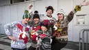 Sebuah keluarga berpose saat berlangsungnya Kejuaraan Dunia Sweater Terjelek di kota Albi, Prancis pada 1 Desember 2018. Kompetisi yang digelar kedua kalinya ini melombakan desain baju hangat yang paling jelek dan paling norak. (ERIC CABANIS / AFP)