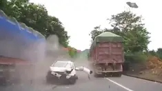 Seorang pengemudi mobil terpental keluar setelah sebelumnya kendaraannya menabrak dua truk.