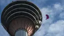 Para penerjun melompat dari dek terbuka Menara Kuala Lumpur saat International Tower Jump, Kuala Lumpur, Malaysia, 3 Februari 2023. Lebih dari 100 penerjun melompat dari Menara Kuala Lumpur setinggi 300 meter yang terkenal tersebut. (MOHD RASFAN/AFP)