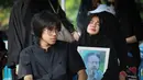 Tubuhnya yang tak berdaya, terus mendekap erat foto suami di sepanjang perjalanan menuju liang lahad. Tampak dalam foto, Karina Ranau (kanan) sesaat sebelum pemakaman suaminya, Epy Kusnandar, di Tempat Pemakaman Umum (TPU) Jeruk Purut, Jakarta Selatan, Kamis (4/12/2025) pagi. (Kapanlagi.com/Budy Santoso)