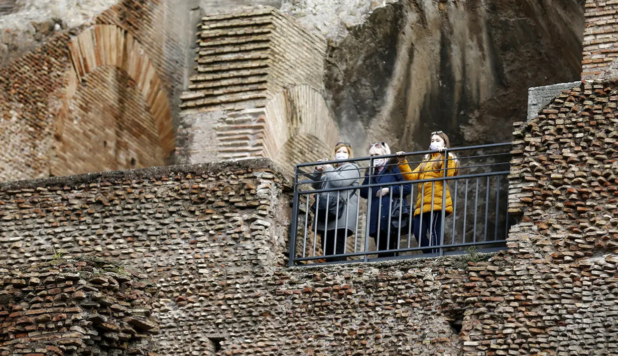 Orang-orang mengunjungi Colosseum setelah kembali dibuka, Roma, Italia, Senin (1/2/2021). Italia mencabut sebagian langkah pembatasan yang bertujuan untuk menahan penyebaran COVID-19 pada 1 Februari 2021. (Cecilia Fabiano/LaPresse via AP)