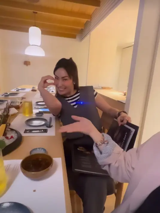 Ayu Dewi kenakan outfit yang boyish dengan striped shirt dan vest abu-abu [@titi_kamall]