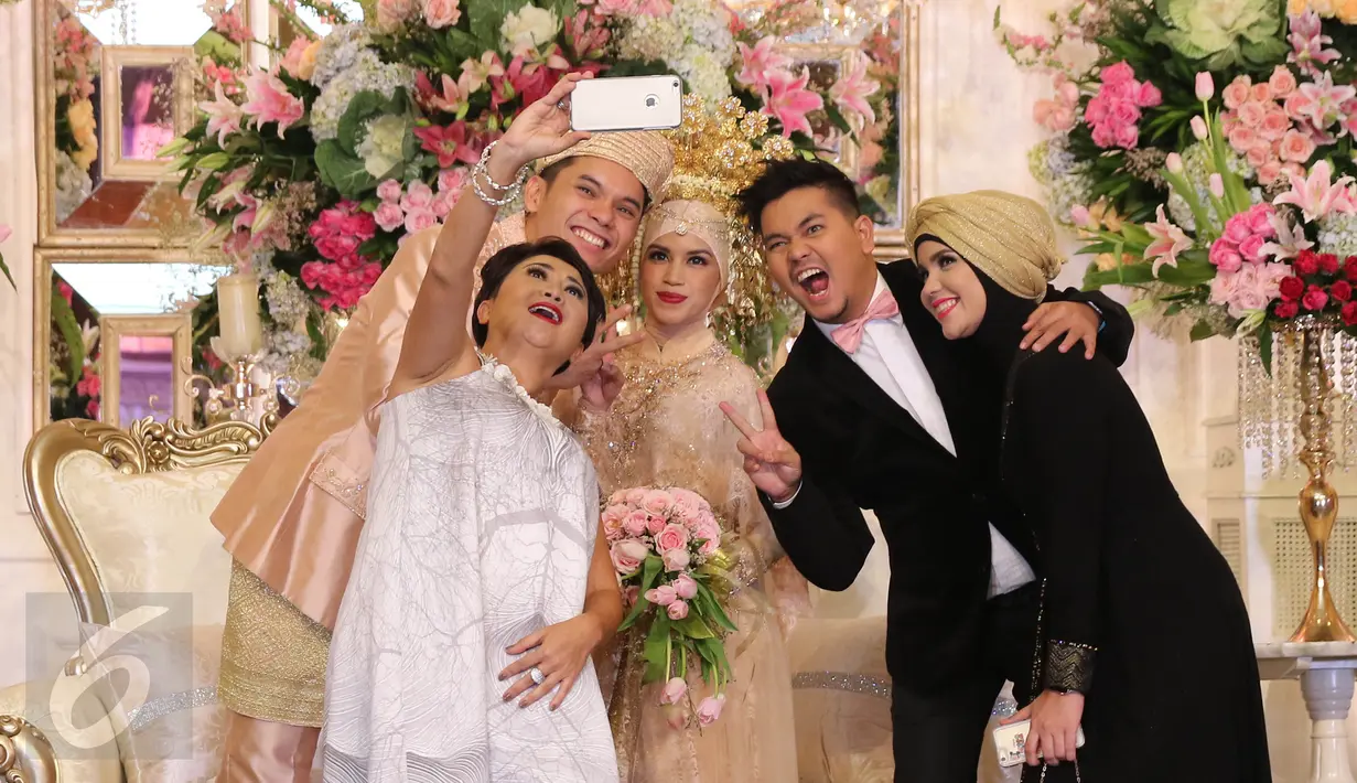 Presenter Indy Barends dan Indra Bekti serta istrinya, Aldila Jelita berwelfie bersama mempelai pengantin Ben Kasyafani - Nesyana Ayu Nabila pada resepsi pernikahan kedua Ben di kawasan Mega Kuningan, Jakarta, Sabtu (30/7). (Liputan6.com/Herman Zakharia)