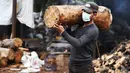 Seorang pekerja menggotong kayu bakar di sebuah bengkel kerja di Damaskus, ibu kota Suriah, pada 23 November 2020. Warga Suriah mengumpulkan kayu bakar untuk menghadapi cuaca dingin. (Xinhua/Ammar Safarjalani)