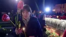 Seorang wanita memegang bunga di depan monumen peringatan 30 tahun bencana nuklir Chernobyl, di kota Slavutych, Ukraina, Selasa (26/4). Ledakan di Chernobyl pada 26 April 1986 silam merupakan kecelakaan terburuk dalam sejarah nuklir. (Genya SAVILOV/AFP)