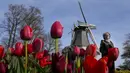 Pengunjung melewati bunga tulip di taman bunga Belanda yang terkenal di dunia, Keukenhof, Lisse, Belanda, 12 April 2022. (AP Photo/Peter Dejong)
