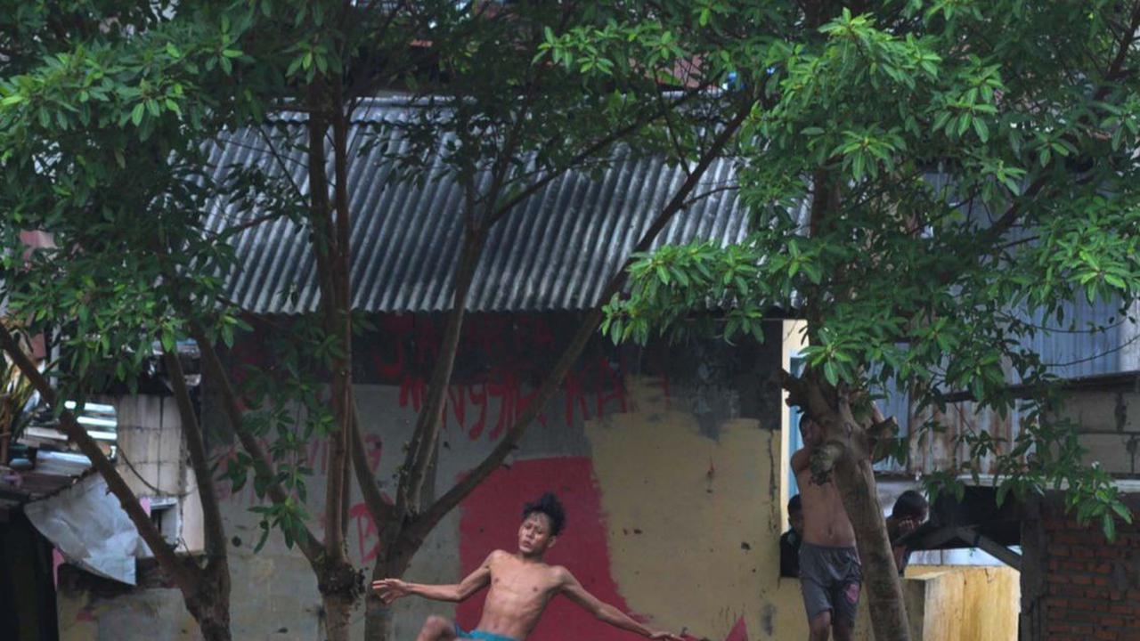 Tanpa pengaman apapun, mereka dengan santai melompat dari pohon dan bangunan, lalu menceburkan dirinya ke aliran Kali Ciliwung.&nbsp;Merdeka.com/Imam Buhori