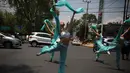 Balerina menampilkan tarian balet saat lampu merah di tengah jalanan Mexico City, 28 Juli 2018. Para balerina dari sanggar Ardentia itu membawakan tarian klasik  untuk menghibur para pengendara di persimpangan yang macet. (AP/Emilio Espejel)